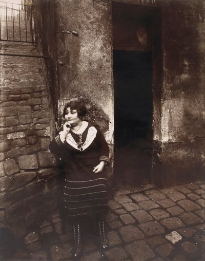 La Villette. Rue Asselin, prostitute waiting in front of her door by Eugène Atget